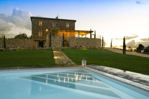 a house with a swimming pool in front of a building at Colle Galli in Acquapendente