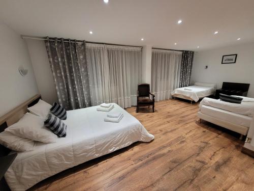 ein Schlafzimmer mit einem Bett, einem Sofa und einem Schreibtisch in der Unterkunft La Croix Blanche in Beaurepaire-en-Bresse