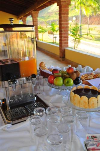 a table topped with a buffet of fruit and bread at Vassouras Eco Resort in Vassouras