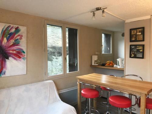 cocina con mesa de madera y taburetes rojos en Appartement Station de ski - Les Agudes - 6 pers, en Gouaux-de-Larboust