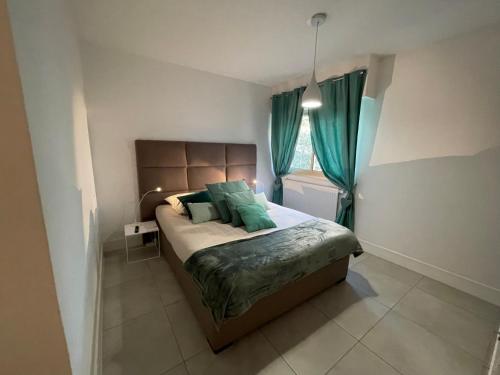 sypialnia z łóżkiem z zielonymi poduszkami i oknem w obiekcie Le Melody w mieście Antibes