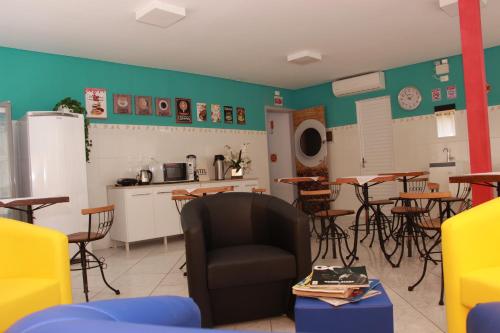 a room with chairs and tables and a kitchen at SAXÔNiA HOTEL in Balneário Camboriú