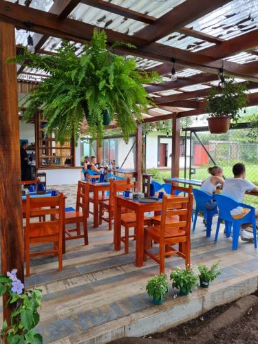 um restaurante com mesas e cadeiras e pessoas sentadas a eles em Aracari Garden Hostel em Tortuguero