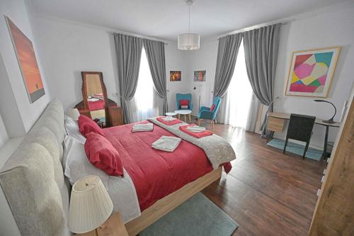 a bedroom with a large bed with a red blanket at Matriz Guest House in Portel