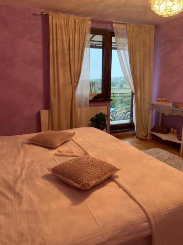 a bedroom with a large bed with a large window at Casa din Deal in Sibiu