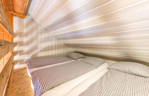two beds in a small room with a wall at Stern LODGE im Bergparadies Lechtal in Boden