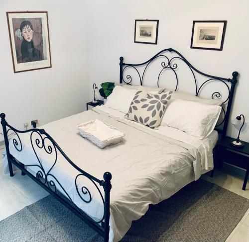 um quarto com uma cama preta e branca com almofadas em Lovely 2 bedroom apartment steps from Ascoli's stunning Piazza del Popolo em Ascoli Piceno