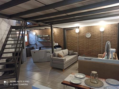 ein Wohnzimmer mit einem Sofa und einer Treppe in der Unterkunft Loft Lomas Del Suquia in Cordoba