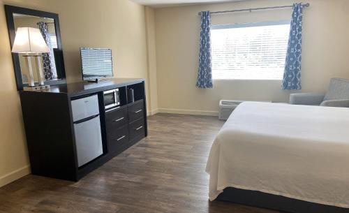 a bedroom with a bed and a dresser with a mirror at University Inn Duke in Durham