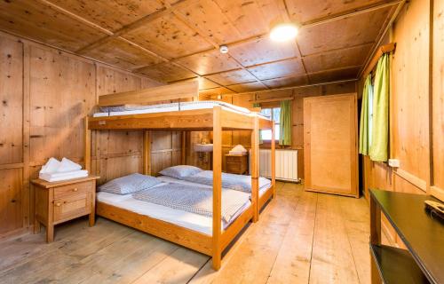a bedroom with a bunk bed in a wooden cabin at Stern LODGE im Bergparadies Lechtal in Boden