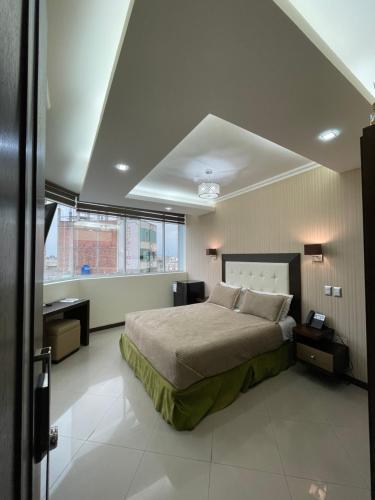 1 dormitorio con cama grande y ventana grande en PALMAR CENTER, en El Guabo