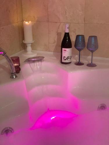 a bottle of wine and wine glasses in a bathroom sink at Casa din Deal in Sibiu