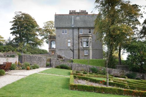 un antiguo castillo con un jardín delante de él en Balmule House, en Dunfermline
