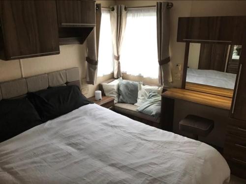 Kama o mga kama sa kuwarto sa The Winchester luxury pet friendly caravan on Broadland Sands holiday park between Lowestoft and Great Yarmouth