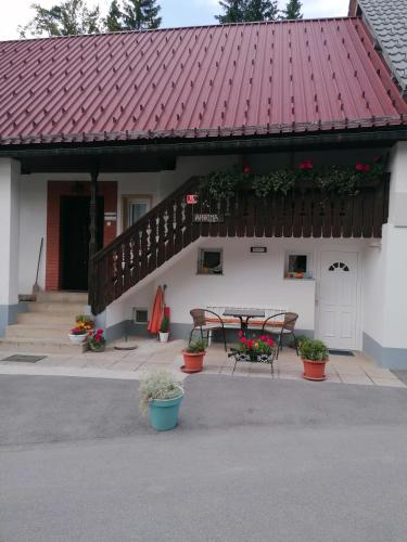 un edificio con tavolo e tetto rosso di Apartmaji Korošec na Koprivniku a Koprivnik v Bohinju
