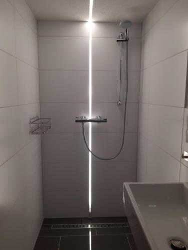 La salle de bains est pourvue d'une douche avec une lumière sur le mur. dans l'établissement Ferienwohnung Zur alten Bäckerei, à Frauenwald