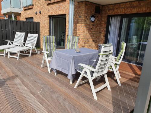 a table and chairs sitting on a deck at AnkerZeit - Wellnesswohnung in Damp in Damp