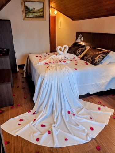 a bed with a dress with hearts on it at Hotel Kehl Haus in Gramado