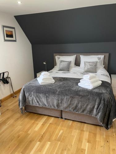 a bedroom with a large bed with two towels on it at An Taigh Mòr in Eriskay