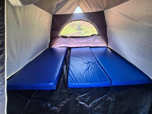 een tent met een blauwe vloer en een raam erin bij Camping Valle das Aguas in Socorro