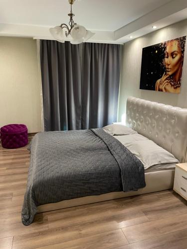 1 dormitorio con 1 cama con una foto en la pared en K.G. Apartment, en Ventspils