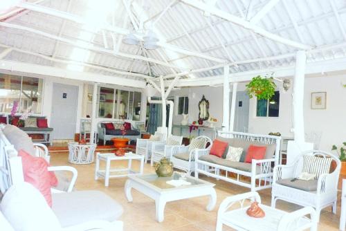 a living room with white chairs and tables at Hotel Ivania´s in Masaya