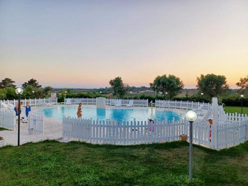 una piscina con recinzioni bianche e persone in acqua di Agriturismo La Rondine a Otranto