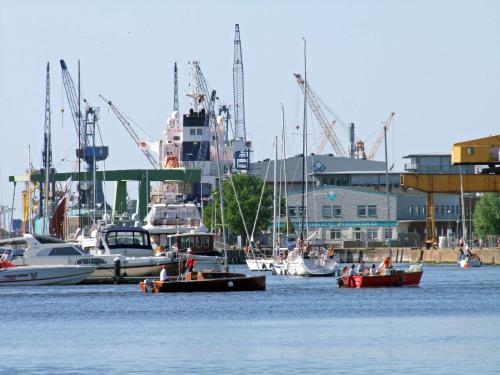 a group of boats floating in the water near a harbor at Atlantic Hotel am Floetenkiel in Bremerhaven