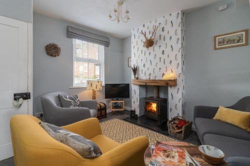 a living room with a couch and a fireplace at Luxury Cottage Nestled in the Heart of Pickering - Pet Friendly in Pickering