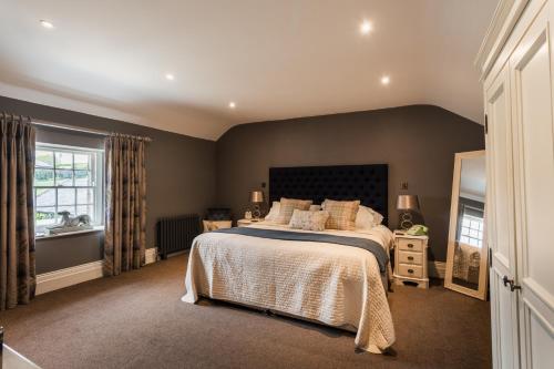 Chatton的住宿－珀西阿姆斯酒店，一间卧室设有一张大床和一个窗户。