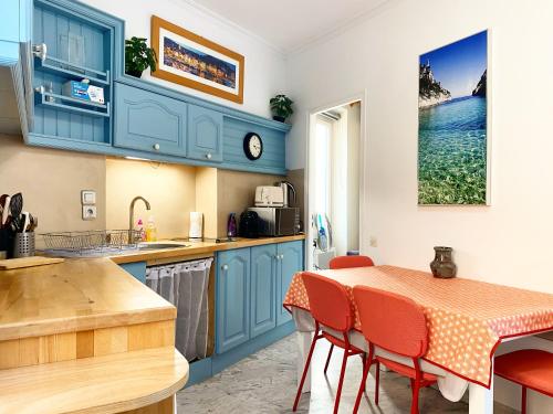 une cuisine avec des armoires bleues et une table et des chaises dans l'établissement Au Cœur de Cassis, à Cassis