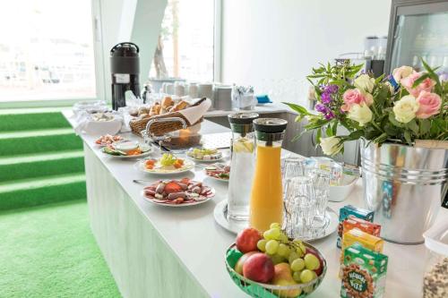a buffet with plates of food and drinks and flowers at Flowers Hotel Münster in Münster
