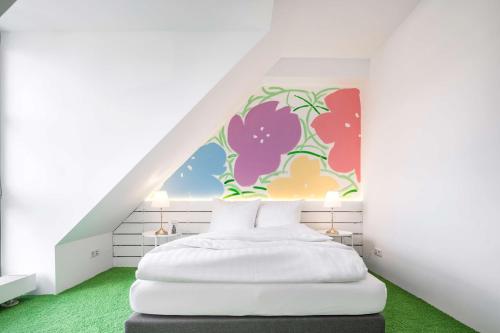 a bedroom with a white bed with a flower mural at Flowers Hotels in Münster