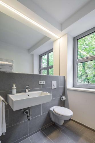 a white bathroom with a sink and a toilet at Flowers Hotel Münster in Münster