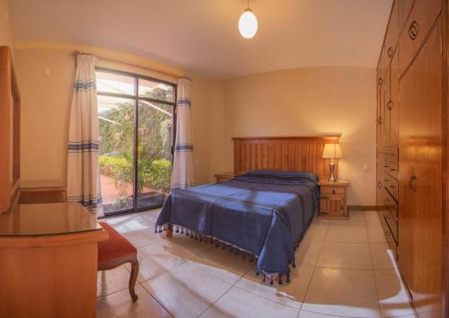 a bedroom with a bed and a large window at Casa del Barrio Apartments Oaxaca in Oaxaca City