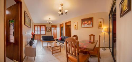a living room with a couch and a table and chairs at Casa del Barrio Apartments Oaxaca in Oaxaca City