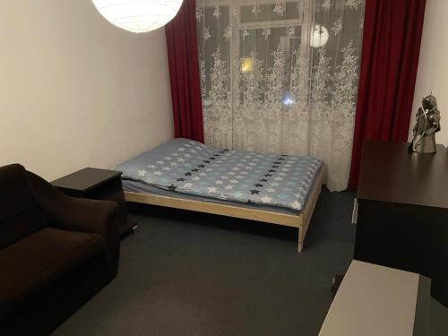 Mieszkanie 2 pokojowe في غدانسك: غرفة نوم صغيرة مع سرير وأريكة