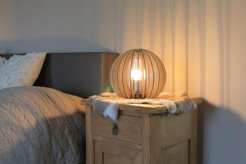 a lamp on a dresser next to a bed at La Veraison in Malmedy