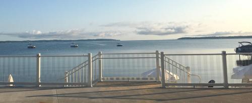 una cerca blanca con barcos en el agua en The Baywatch Resort en Traverse City