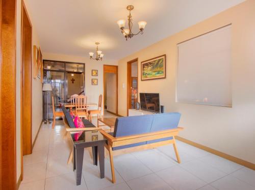 a living room with a blue couch and a table at Casa del Barrio Apartments Oaxaca in Oaxaca City