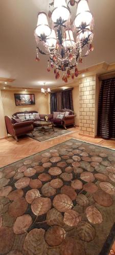 a large living room with a chandelier and a large rug at Nasr City Royal in Cairo