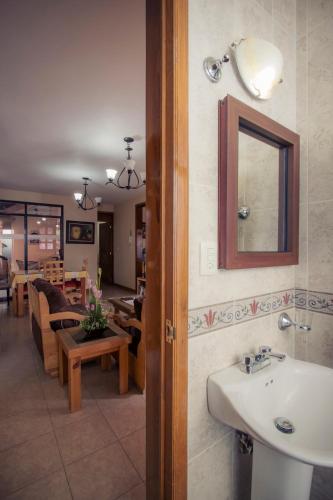 a bathroom with a sink and a living room at Casa del Barrio Apartments Oaxaca in Oaxaca City