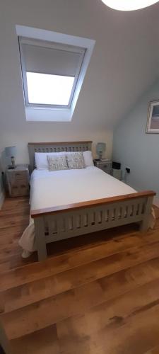 a bedroom with a large bed with a skylight at Blacksmiths in Dartmouth