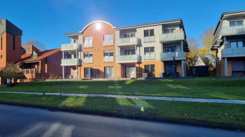a large apartment building with a green lawn in front of it at AnkerZeit - Wellnesswohnung in Damp in Damp