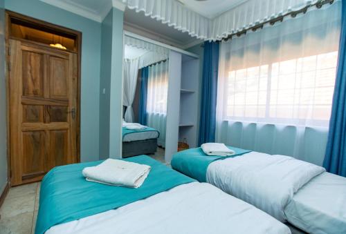 Ένα ή περισσότερα κρεβάτια σε δωμάτιο στο Villa Karibu Serviced Apartments-Kampala