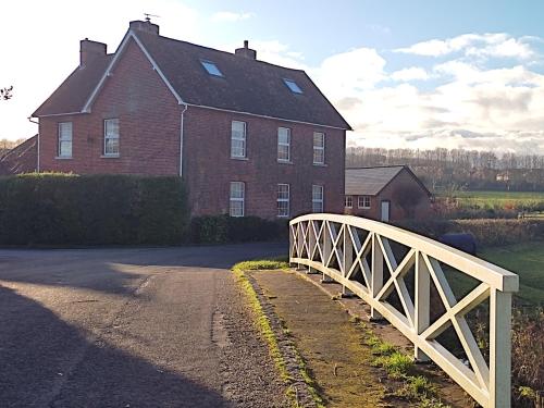 a bridge in front of a house with a building at The Cheesehouse in Salisbury