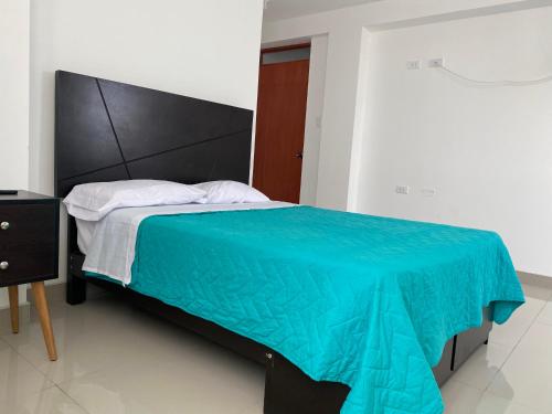 a bedroom with a bed with a blue blanket at Hotel Munay in Paracas