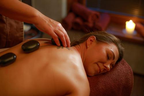 a woman getting a back massage at a salon at Johan Suites & Spa in Kuressaare
