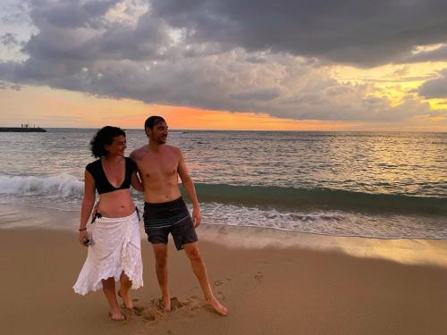 a man and a woman standing on the beach at Hikka Sands & SPA in Hikkaduwa