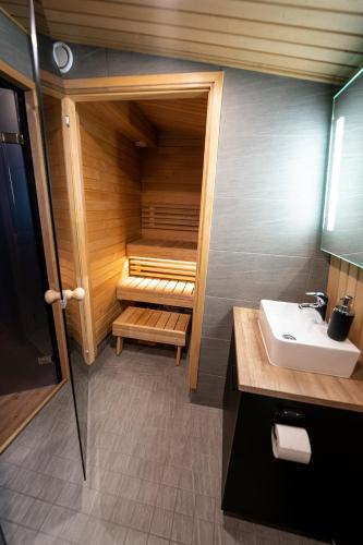 a bathroom with a sauna with a sink and a toilet at Black Hotel in Kempele